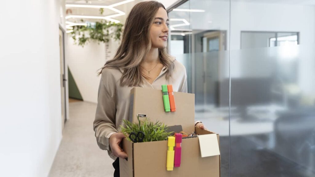 femme quittant son travail carton dans les mains